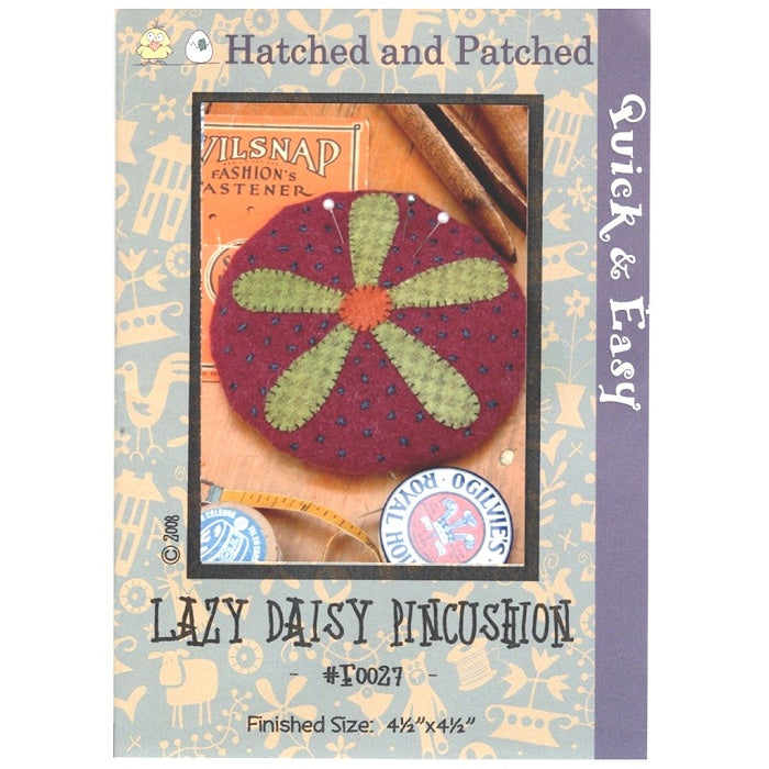 Pattern cover of red pincushion with green daisy applique.