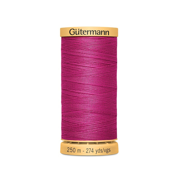 Spool of dark pink cotton thread with Gutermann branding.