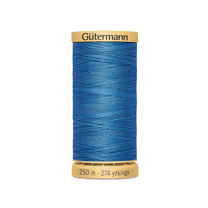 Spool of blue cotton thread with Gutermann branding.