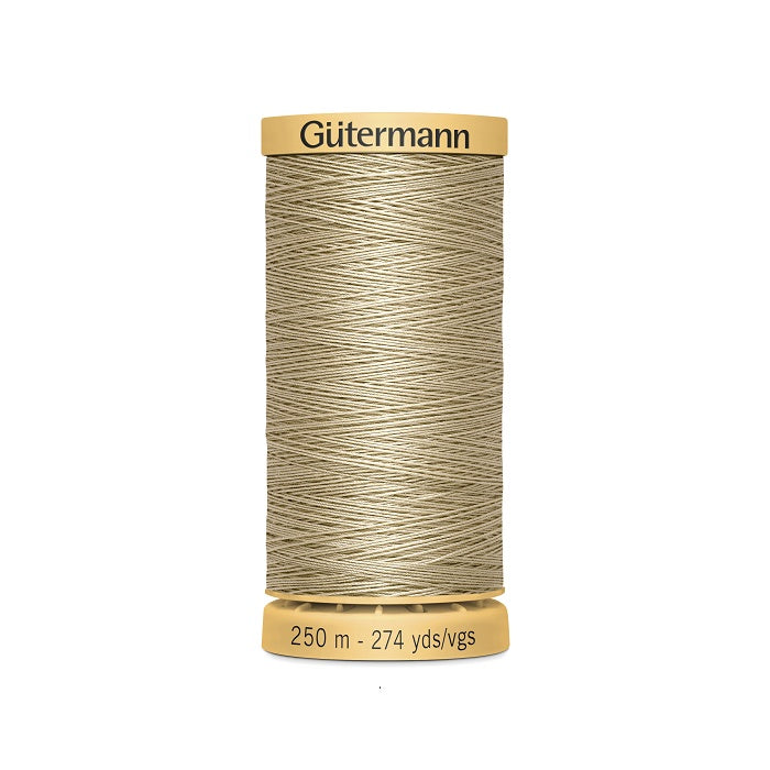 Spool of beige cotton thread with Gutermann branding.