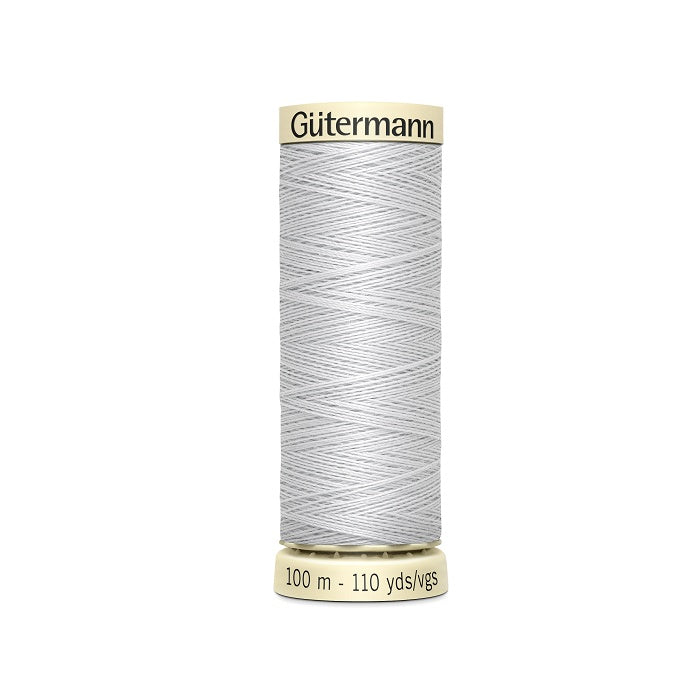 Spool of light grey thread with Gutermann branding.