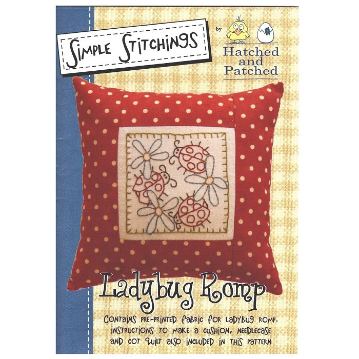 Pattern cover of red spotty cushion with embroidered ladybugs.
