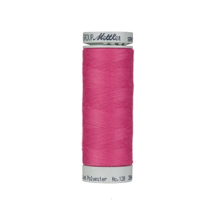 Spool of hot pink thread with Mettler Seracycle branding.