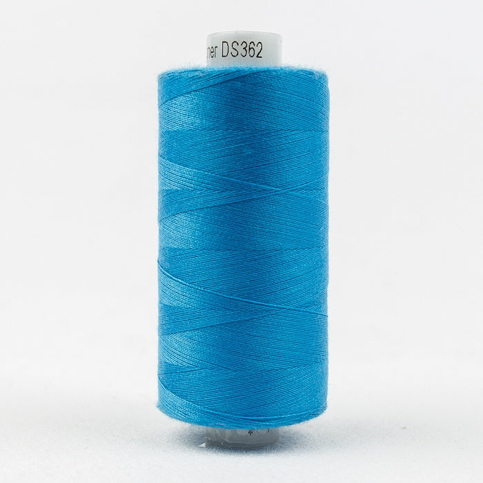 Spool of blue thread with Designer branding.