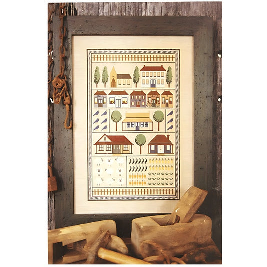 Framed cross stitch with rows of country themed houses.