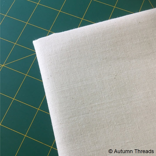 Folded calico fabric on a cutting mat.