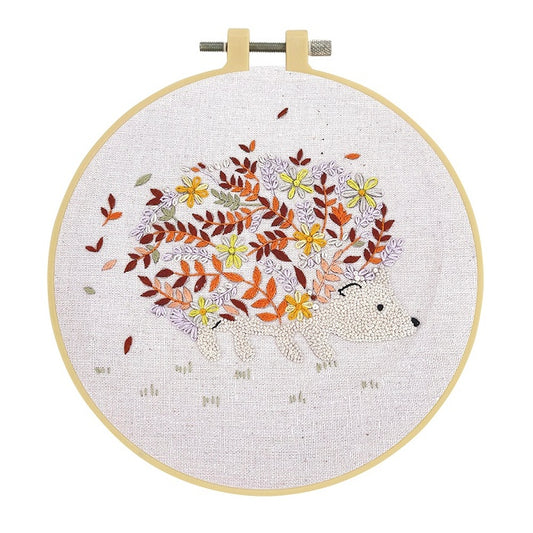 Embroidery hoop with an autumn coloured floral hedgehog and beige background.