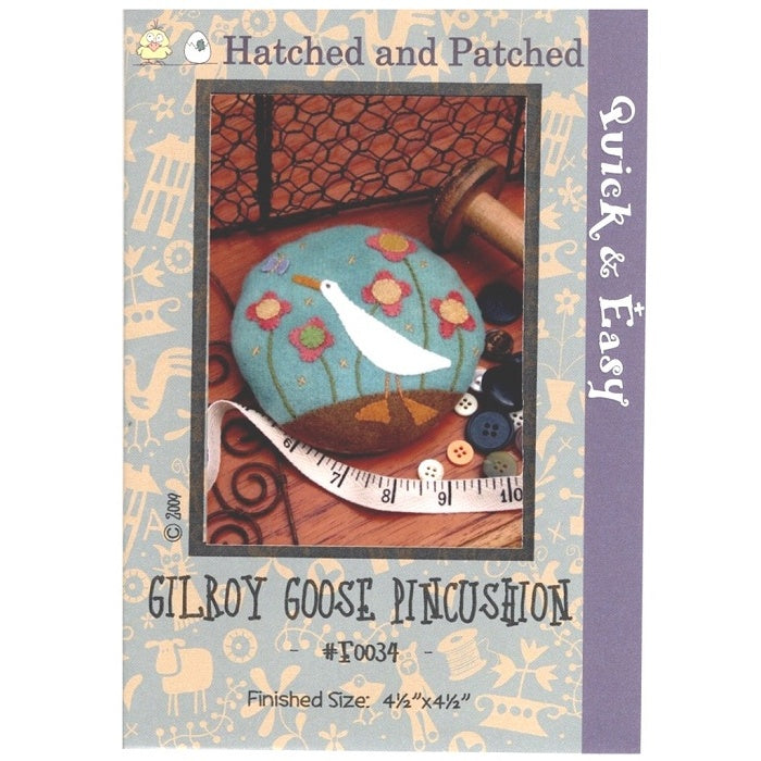 Pattern cover of pincushion with appliqued white goose and flower garden.
