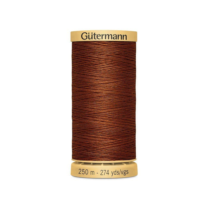Spool of red cotton thread with Gutermann branding.