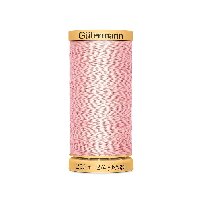 Spool of pink cotton thread with Gutermann branding.