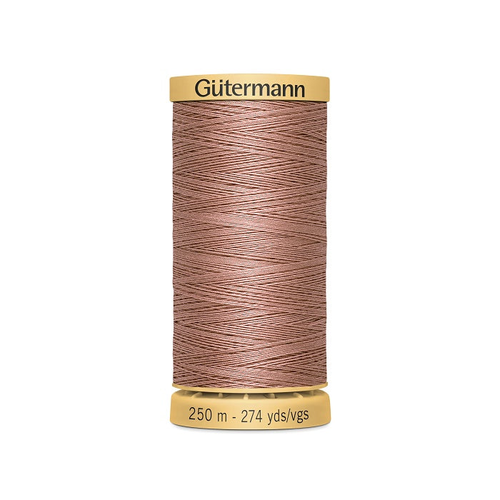 Spool of dark dusty pink cotton thread with Gutermann branding.
