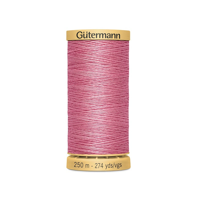 Spool of pink cotton thread with Gutermann branding.