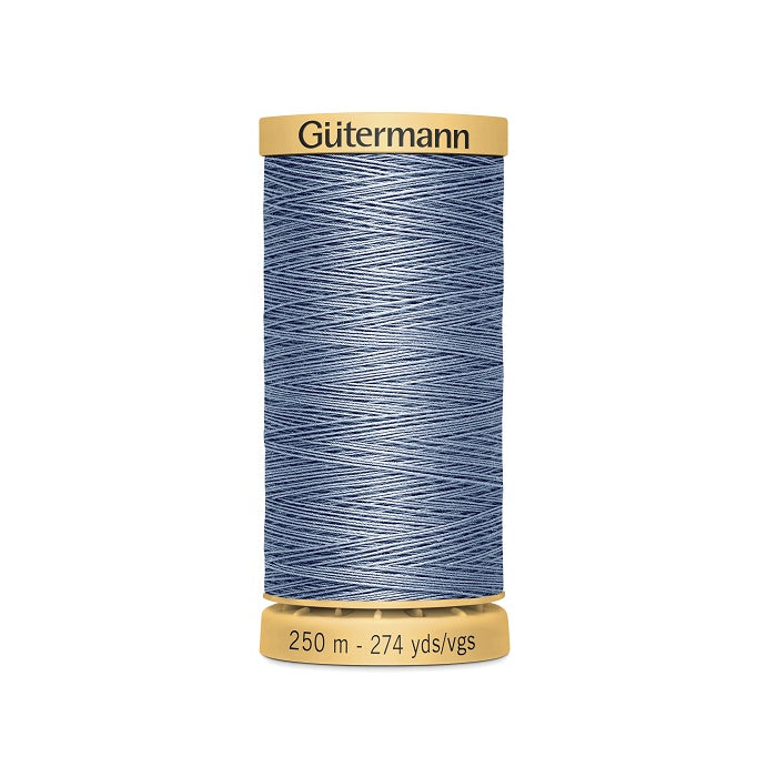 Spool of dusty blue cotton thread with Gutermann branding.