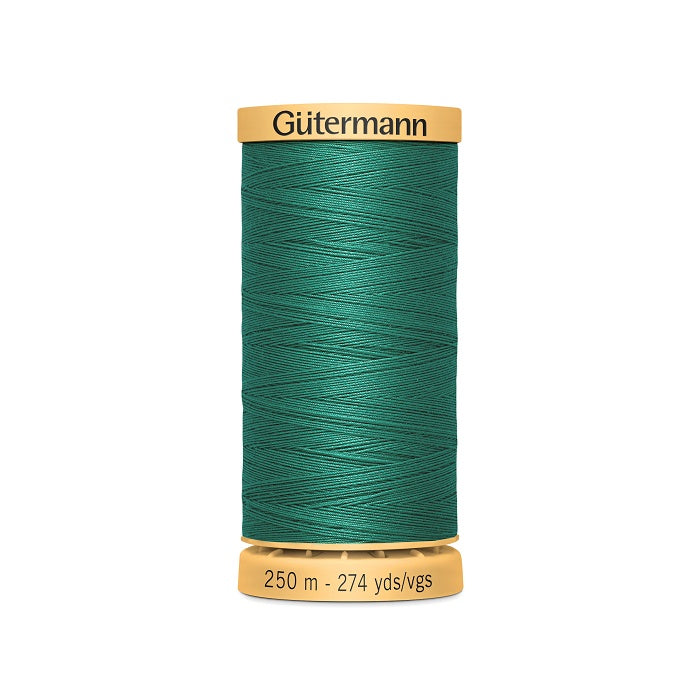Spool of green cotton thread with Gutermann branding.