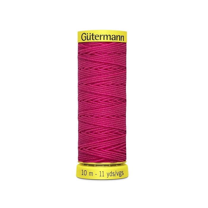 Hot pink elastic sewing thread spool with gutermann branding.