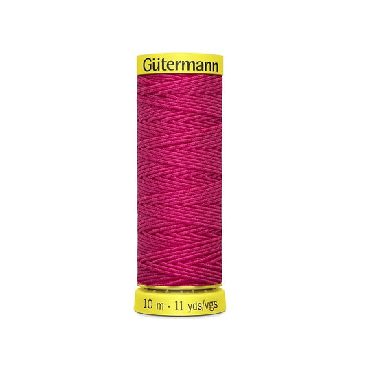Hot pink elastic sewing thread spool with gutermann branding.