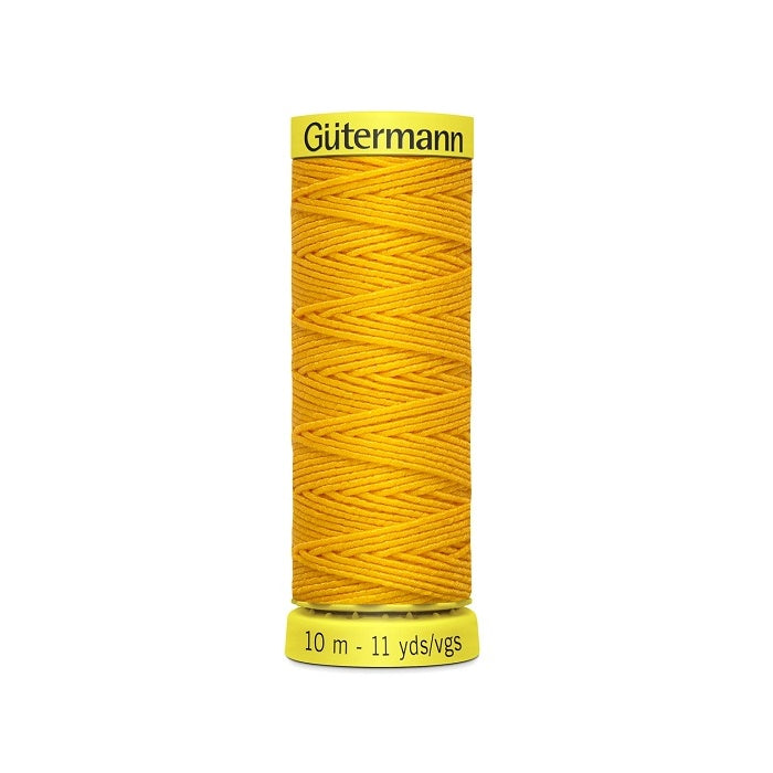 Sports gold elastic sewing thread spool with gutermann branding.
