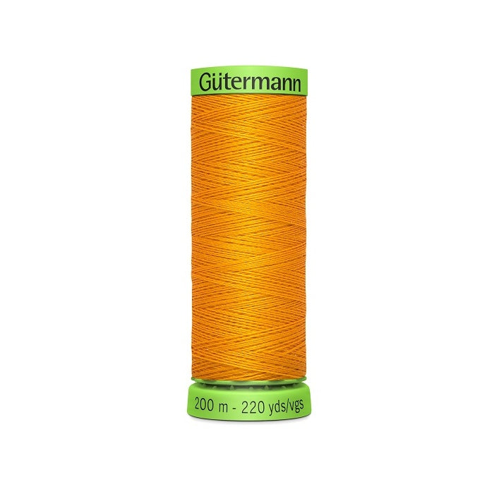 Spool of dark yellow extra fine thread with Gutermann branding.