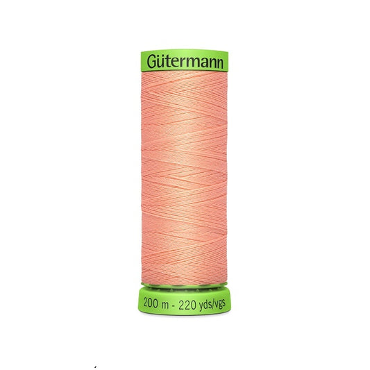 Spool of peach pink extra fine thread with Gutermann branding.