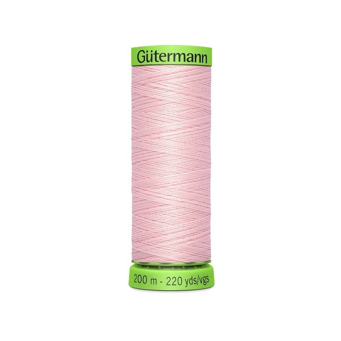 Spool of pink extra fine thread with Gutermann branding.