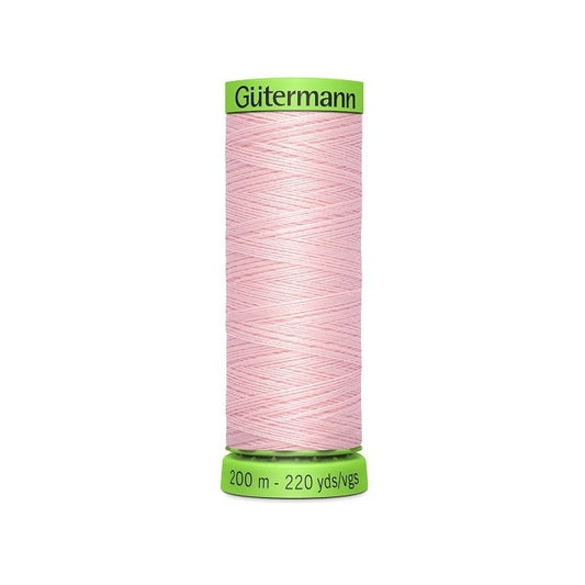 Spool of pink extra fine thread with Gutermann branding.
