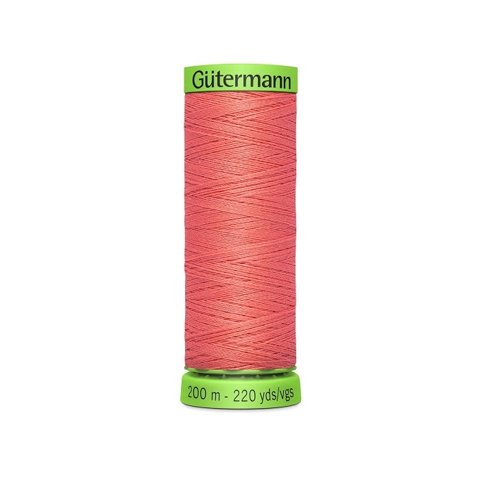 Spool of dark salmon pink extra fine thread with Gutermann branding.