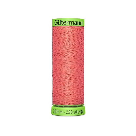 Spool of dark salmon pink extra fine thread with Gutermann branding.