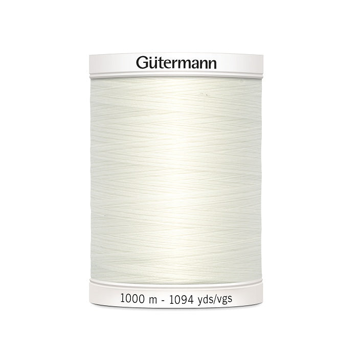 Off white sewing thread spool with Gutermann branding.