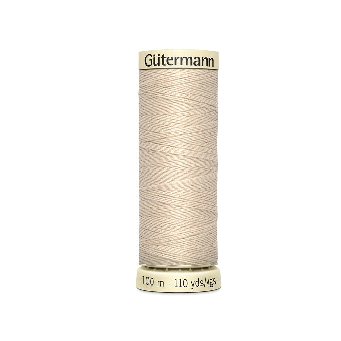 Spool of beige thread with Gutermann branding.