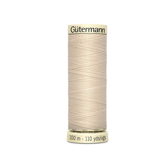 Spool of beige thread with Gutermann branding.