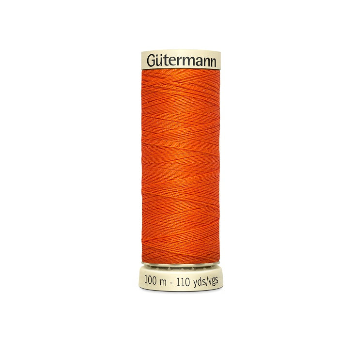 Spool of orange thread with Gutermann branding.