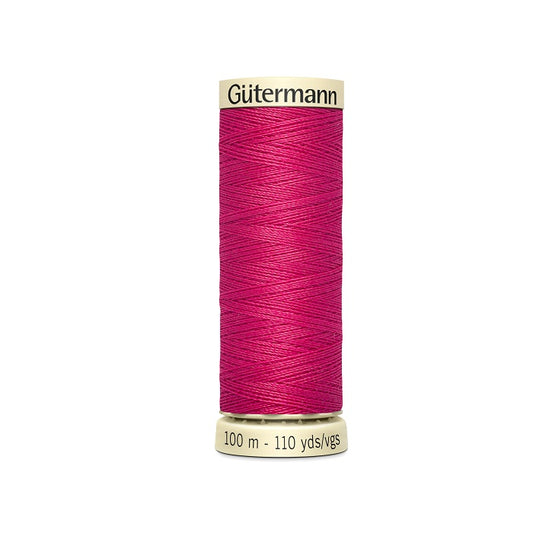Spool of dark pink thread with Gutermann branding.
