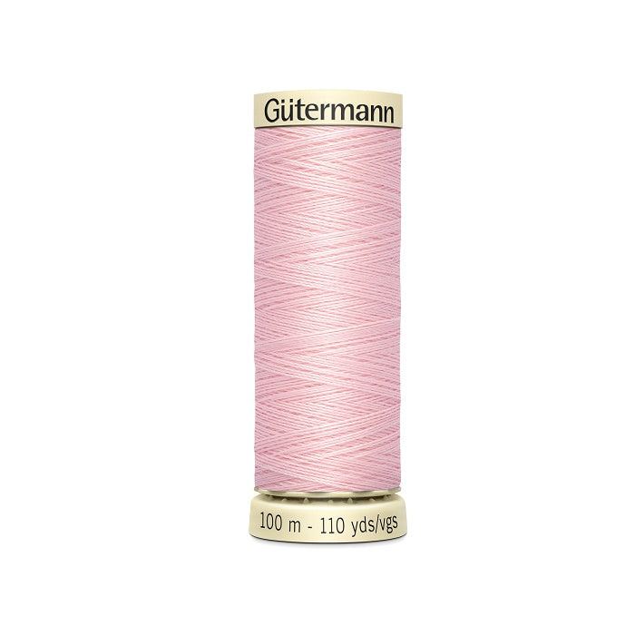 Spool of pink thread with Gutermann branding.