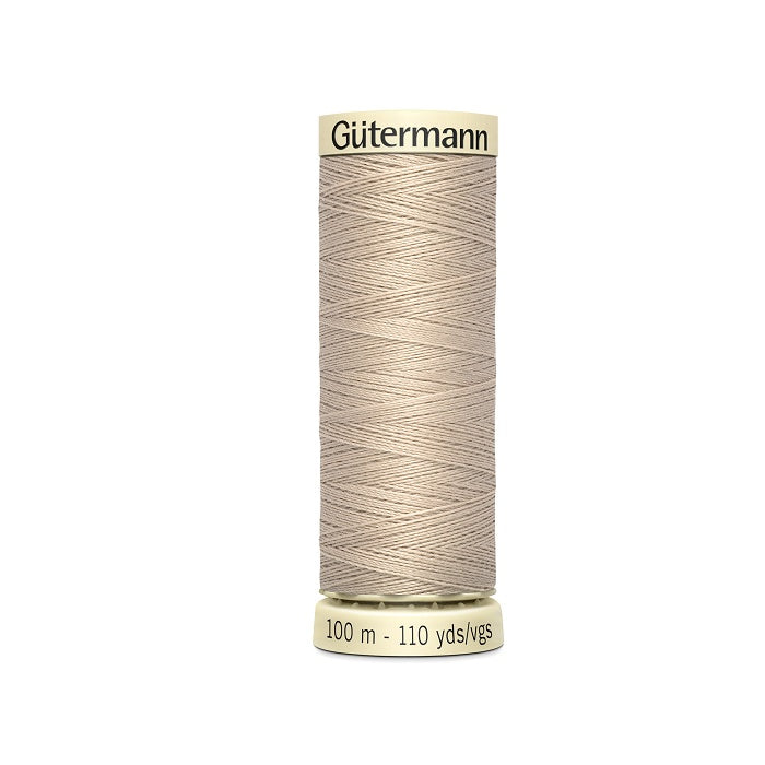 Spool of beige thread with Gutermann branding.