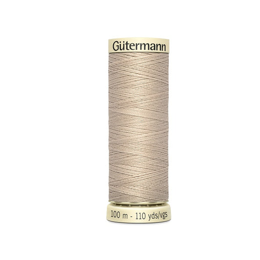 Spool of beige thread with Gutermann branding.