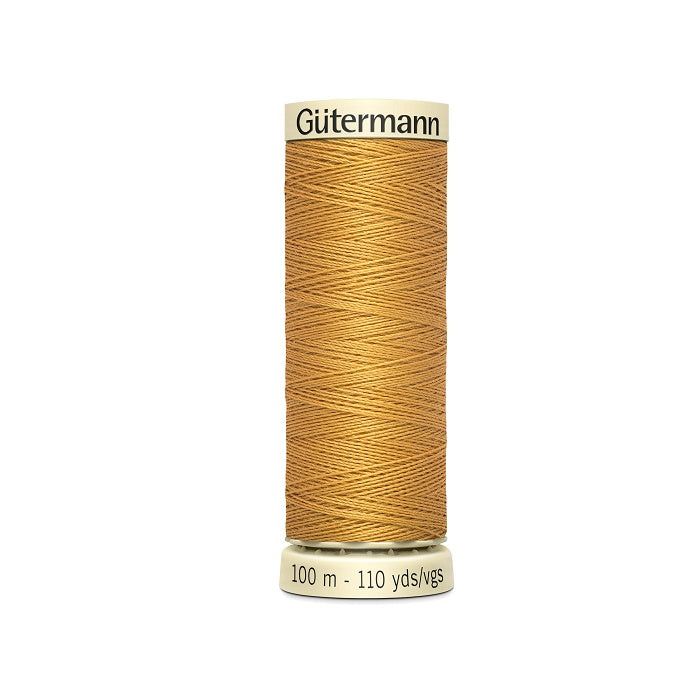 Spool of gold thread with Gutermann branding.