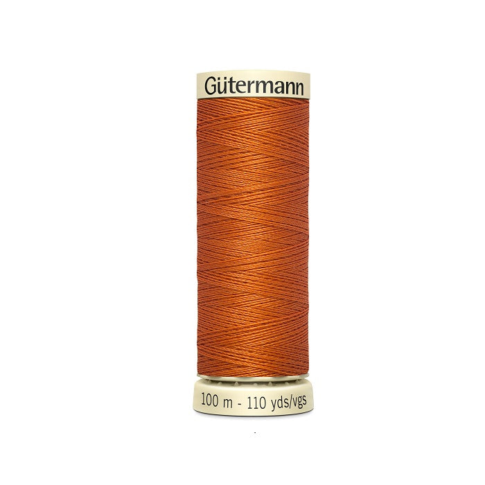 Spool of orange thread with Gutermann branding.
