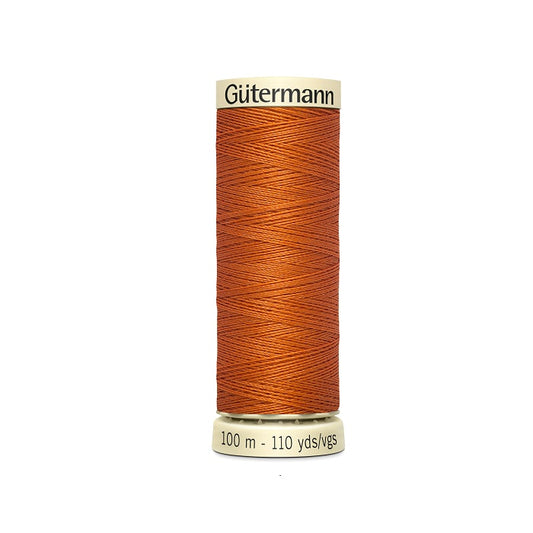 Spool of orange thread with Gutermann branding.
