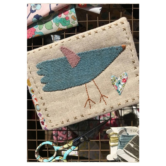 Fabric needlebook with embroidered bird design.