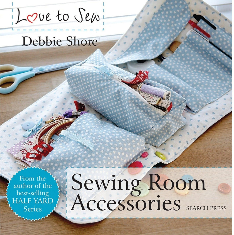 Book cover with sewing supplies in a fabric roll on a table.