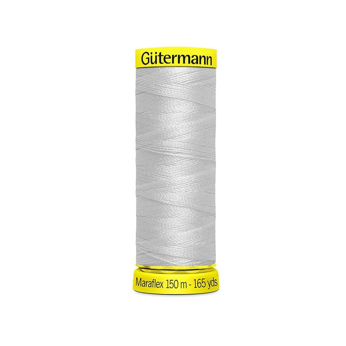 Spool of light grey elastic thread with gutermann branding.