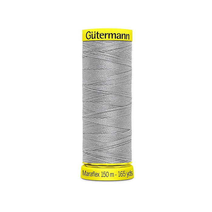 Spool of grey elastic thread with gutermann branding.