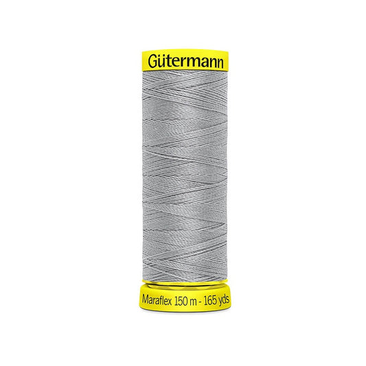 Spool of grey elastic thread with gutermann branding.