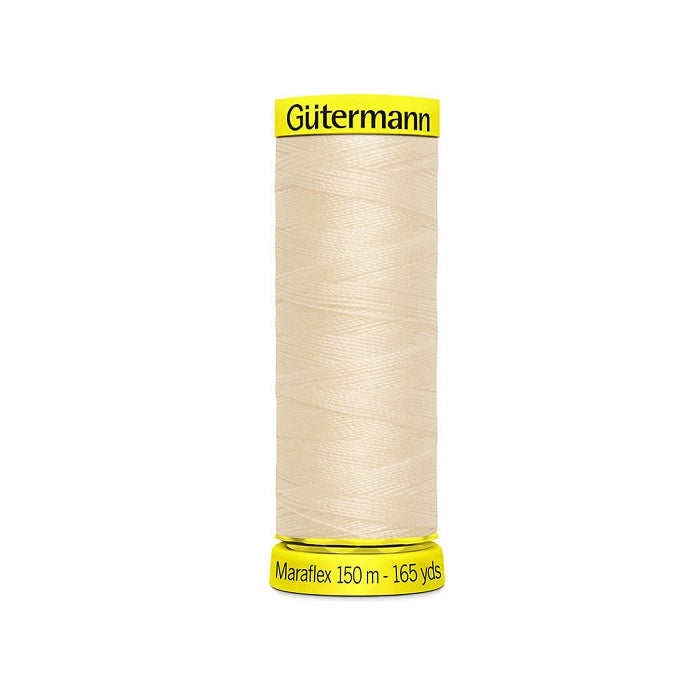 Spool of cream elastic thread with gutermann branding.