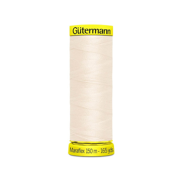 Spool of natural elastic thread with gutermann branding.