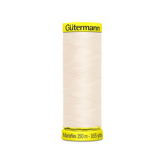 Spool of natural elastic thread with gutermann branding.