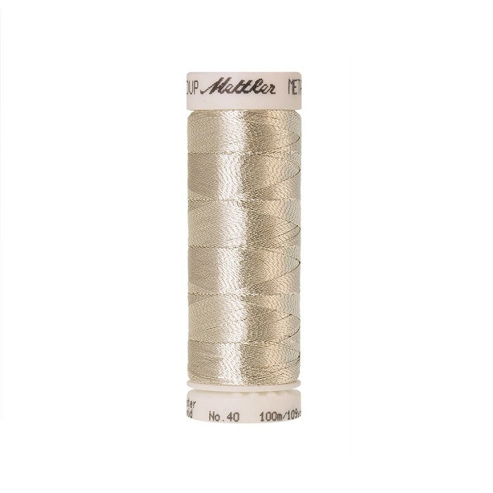 Spool of beige silver metallic thread with Mettler branding.