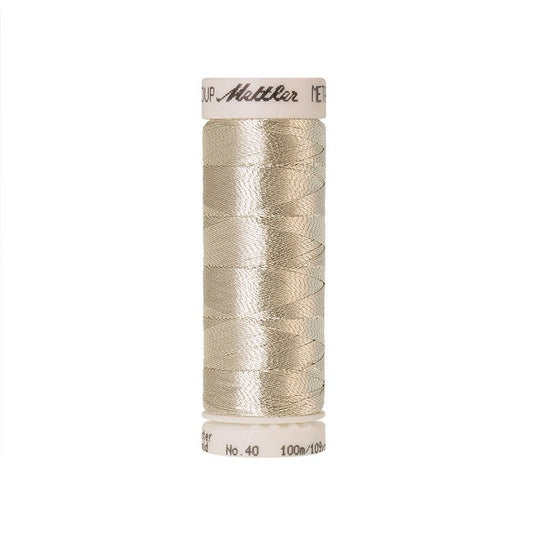 Spool of beige silver metallic thread with Mettler branding.