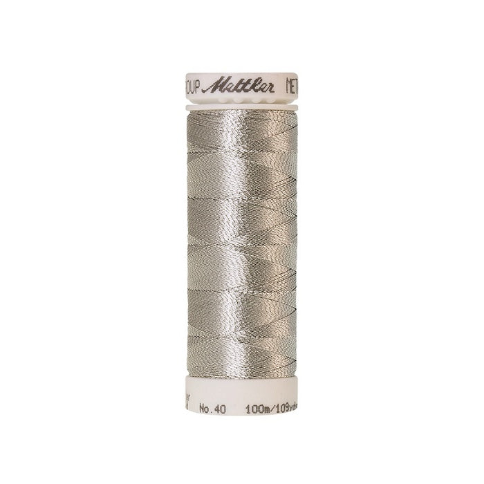 Spool of silver metallic thread with Mettler branding.