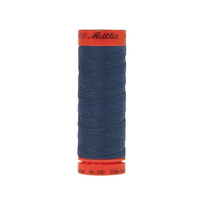 Spool of Mettler 150m dark dusky blue thread.